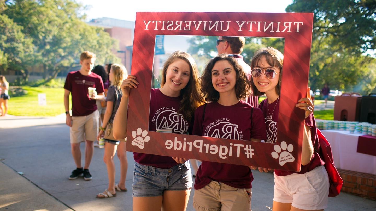 Students taking photo with giant photo frame that says Trinity University TigerPride